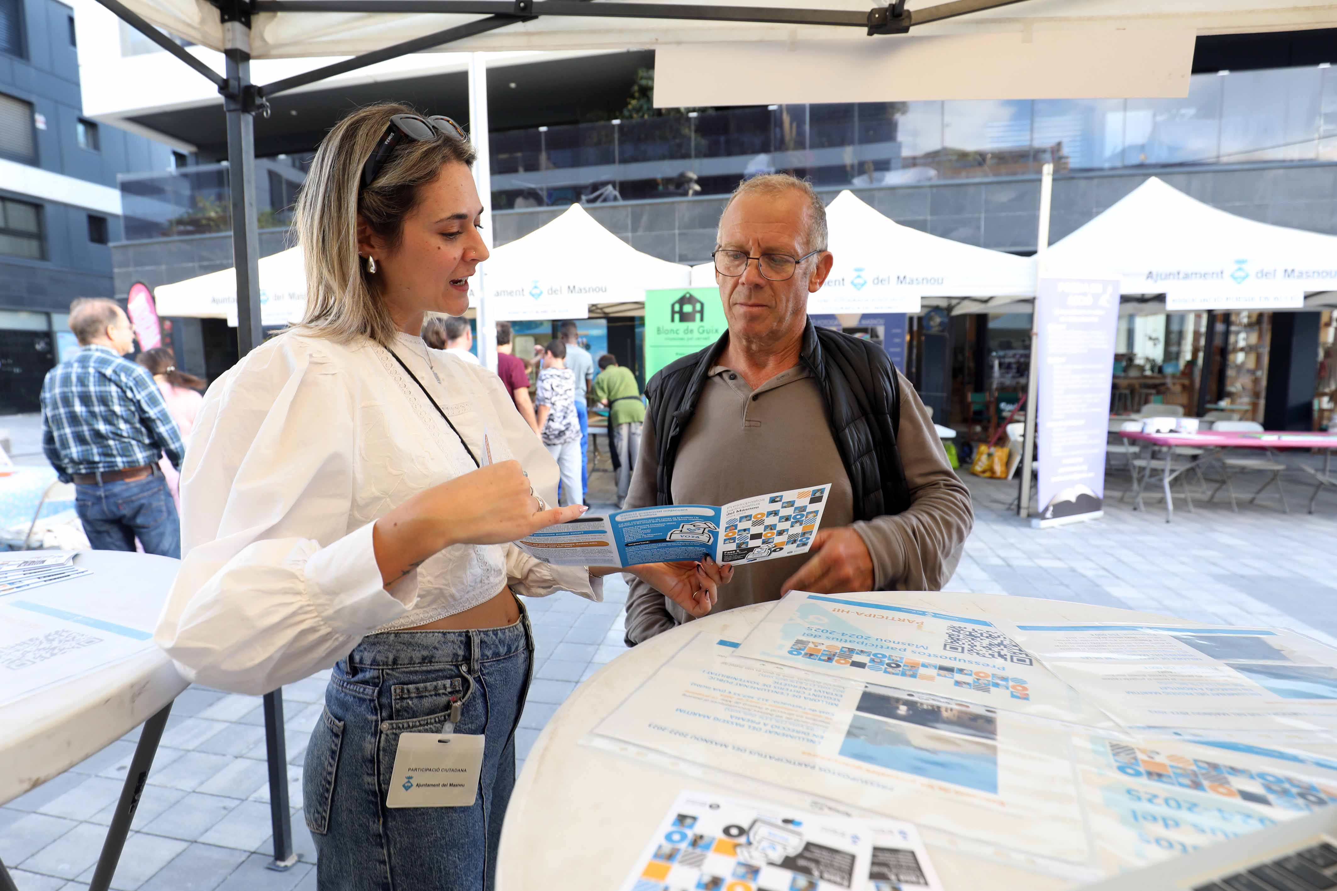 Foto de persones votant presencialment a la Fira d'Entitats 2024.