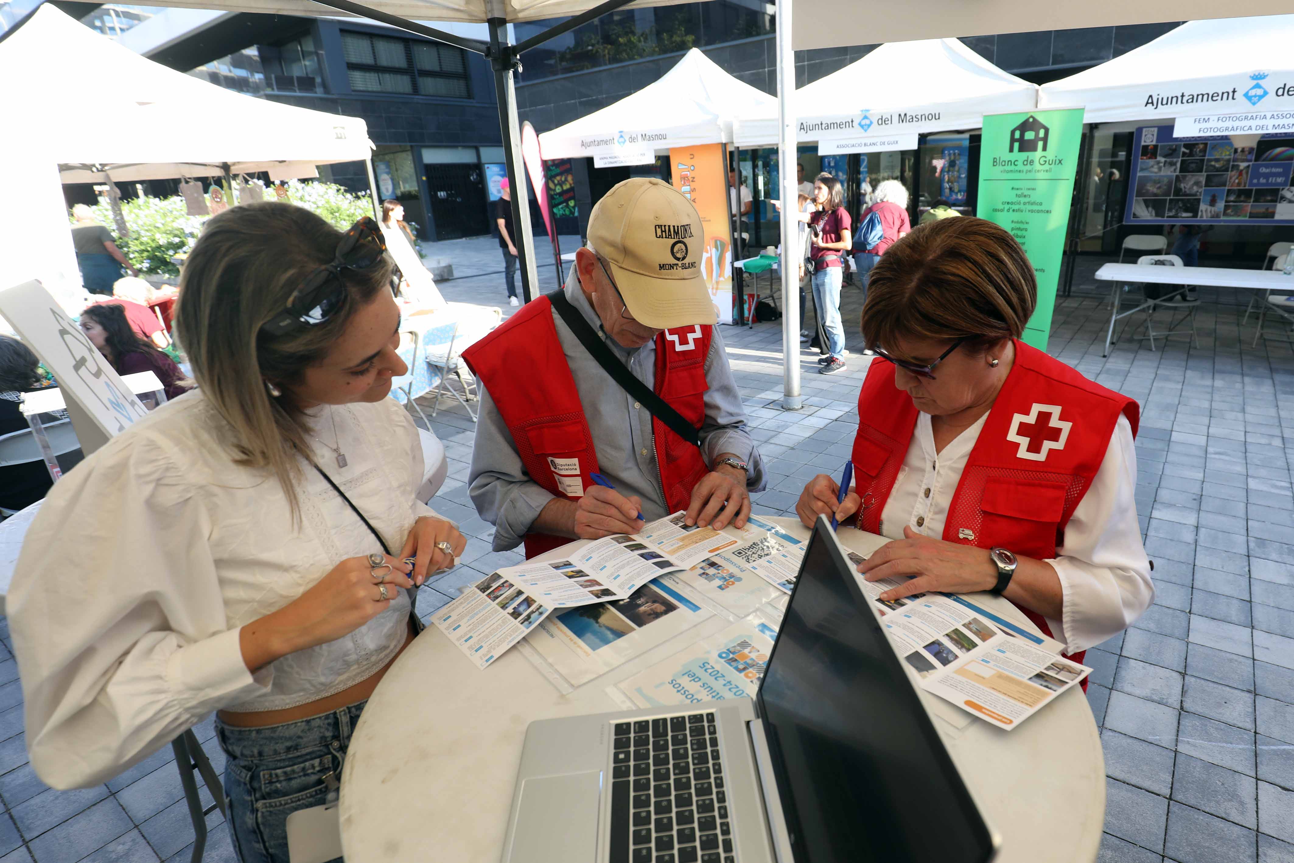 Foto de persones votant presencialment a la Fira d'Entitats 2024.